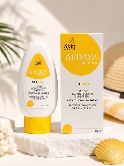 Alldayz Sunblock SPF 100+ sunscreen bottle and matching box, styled on a white stone surface with seashells and warm sunlight.